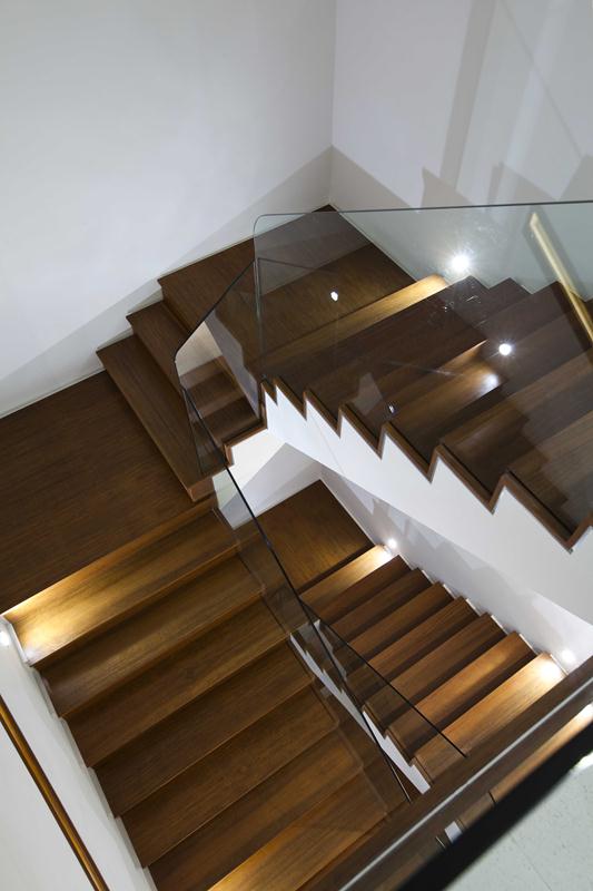 Thiết kế cầu thang có dạng gấp khúc với chất liệu gỗ kết hợp lan can kính hiện đại